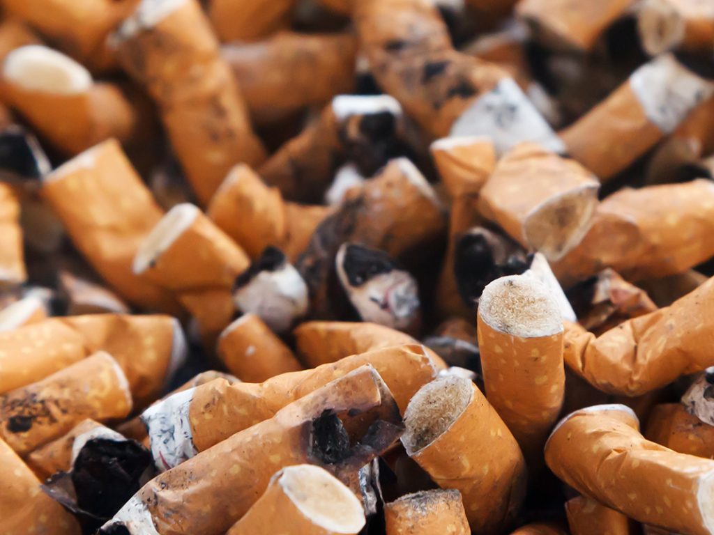 Nahaufnahme eines Aschenbechers voller ausgedrückter Zigaretten