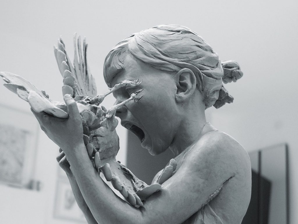 Eine Frau ist kurz davor in eine Taube zu beißen. Skulptur "Trau, Schau, Wem" (2011) von Kristin Kolb
