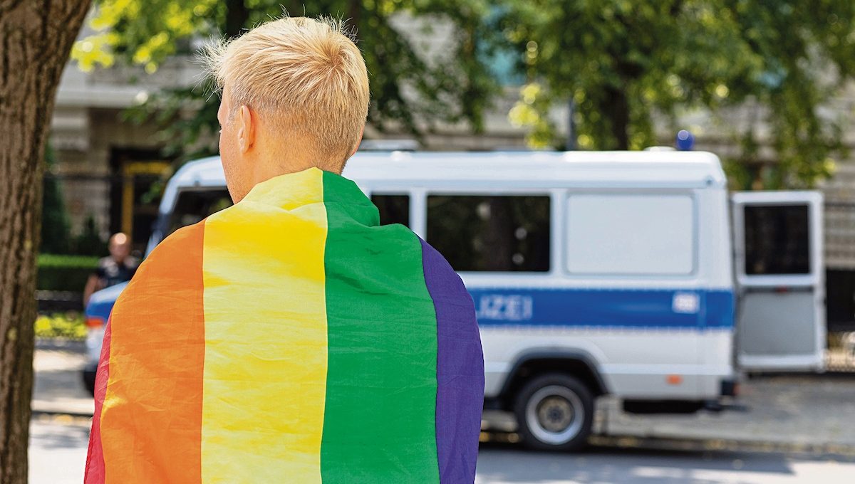 Demonstrant mit Regenbogenflagge